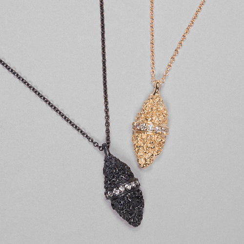 Textured, marquise-shaped necklace; diamond stripe bissects piece left to right across middle; shown in polished gold and blackened silver