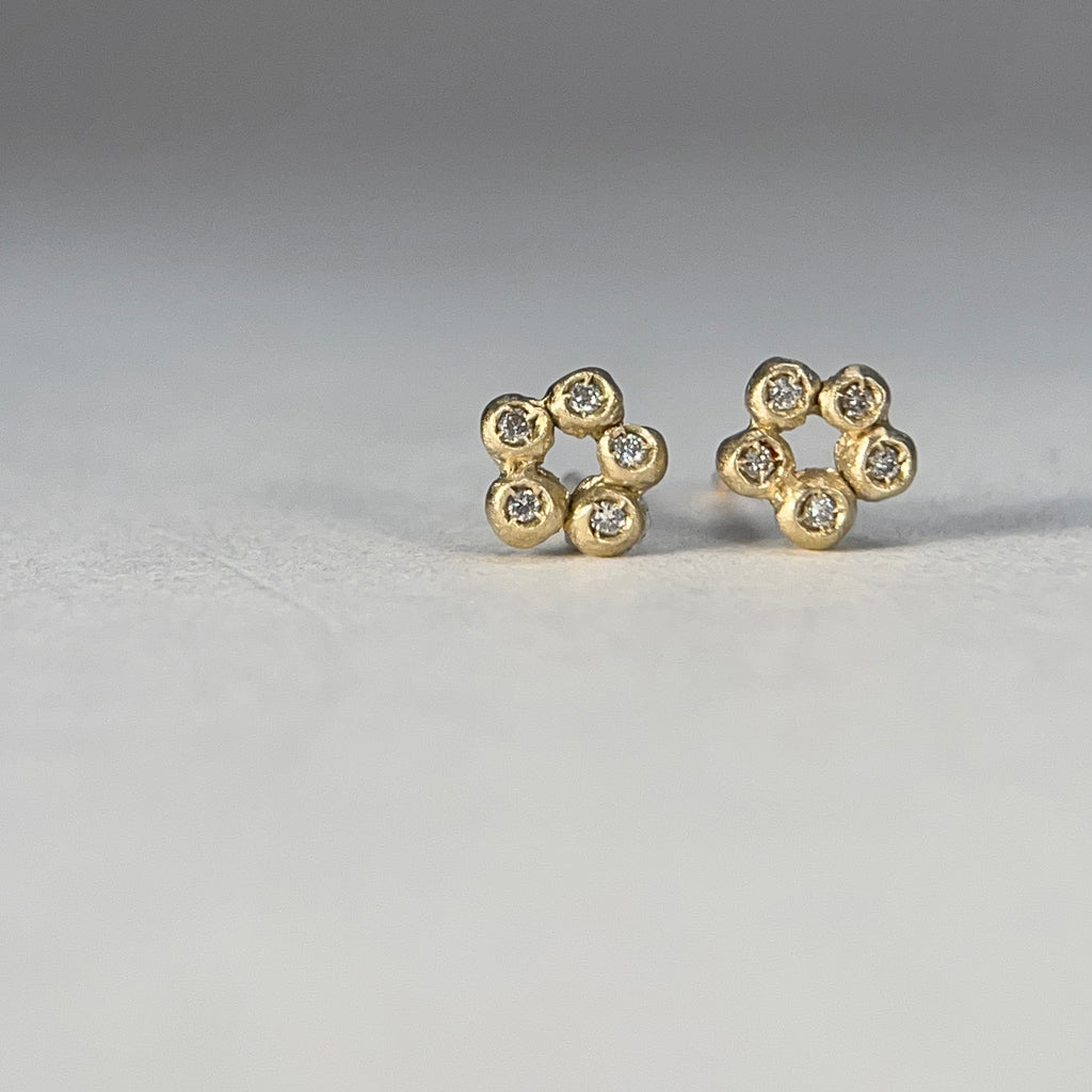 a stud made of 5 small bud-like balls in an open circle, each one set with a diamond; shown in 14k yellow