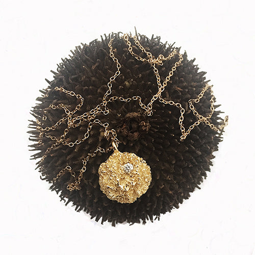 Textured mushroom-like puff with diamond in top right quadrant; shwon in polished gold