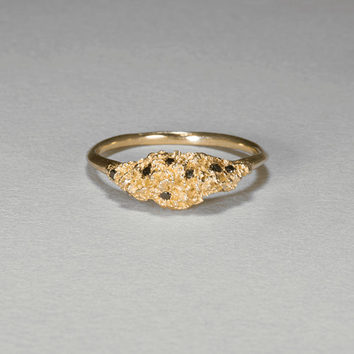 Textured hill-like shape taking up top 1/3 of ring; poished band; set with scattering of black diamonds