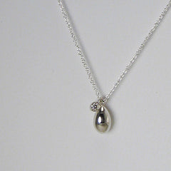 Shiny, solid egg with diamond bezel charm, shown in silver.
