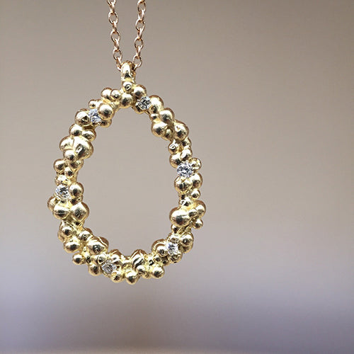 Large, open, egg-shaped pendant made of tightly-clustered beans or pods, studded with diamonds