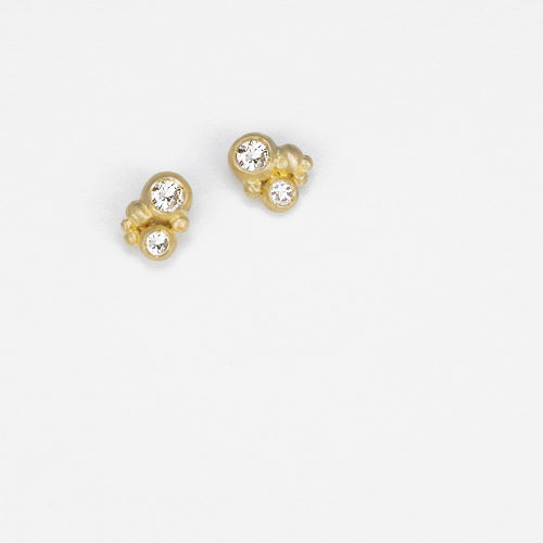 Two large diamond pods set in cluster of small buds; stud earring