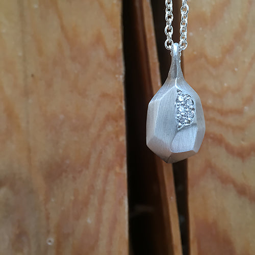 Faceted pear-like pendant with pavé diamonds in one facet; shown in silver