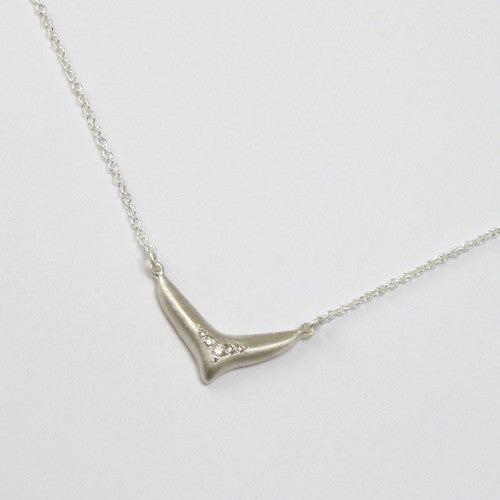 Elongated, fishtail-like pendant with arch of 5 diamonds following the shape; shown in matte silver