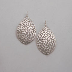 leaf-shaped, slightly convex earring on wire; has overall pattern made by organic cutouts; shown in silver