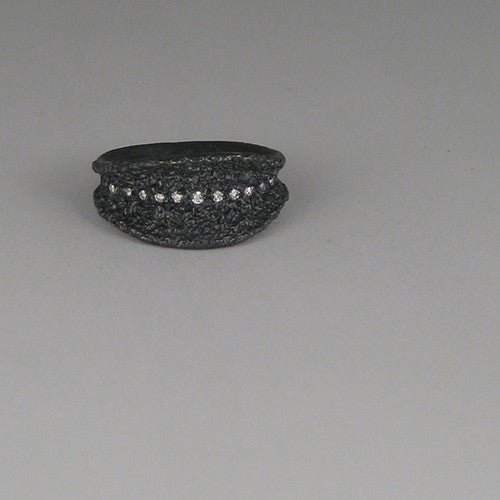Textured, leaf-like shape with line of diamonds running top to bottom; shown in blackened silver with white diamonds; concave with flared edges