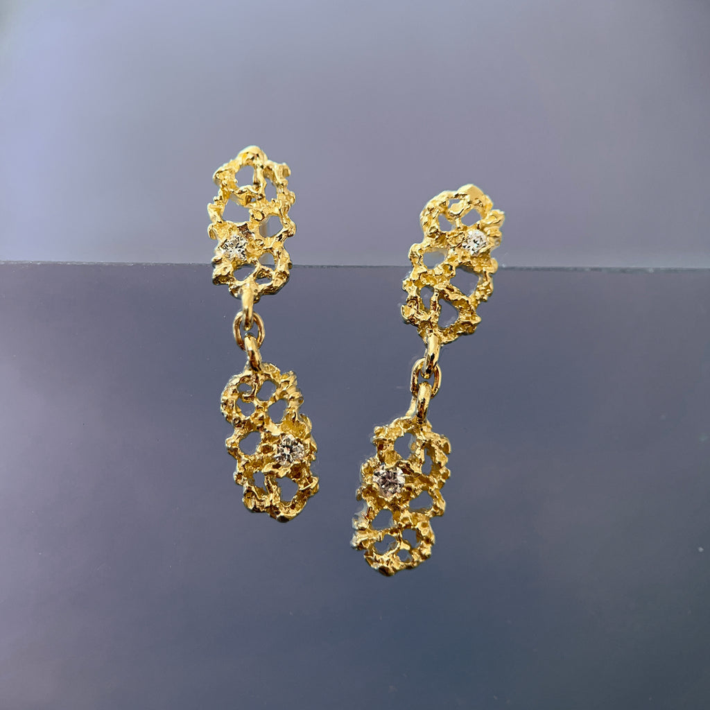 textured earrings with negative space made up of two similar components: soft rectangles that hang end to end, each with a small white diamond; shown in 14k yellow