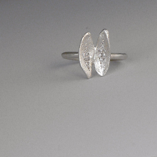 Elongated, oyster-like shape at top of band; cracked-open "shell:" with various-sized diamonds clustered in center of each half