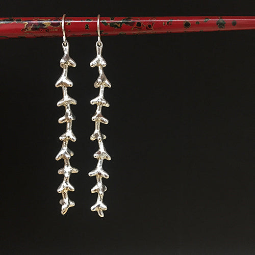 Long, spiky earring in polished silver