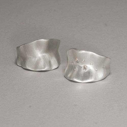 Wide band that narrows at bottom; resembles slightly ruffled leaf with softly hilly edges; shown with and without diamonds