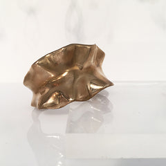 Substantial cuff made to look like large ruffled leaf wrapped around wrist; soft hilly edges; shown in polished bronze