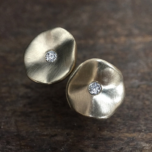 Soft, round, organic, slightly concave stud earring with hilly edges and center diamond