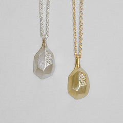 Faceted pear-shaped pendant with pavé diamonds in one facet; shown in silver and yellow gold