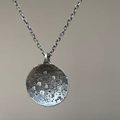 Concave dome pendant is textured and slightly darkened; shown with diamond scatter option