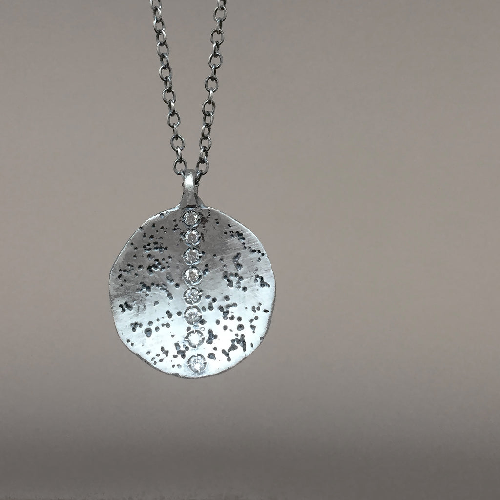 Concave dome pendant is textured and slightly darkened; shown with diamond stripe option