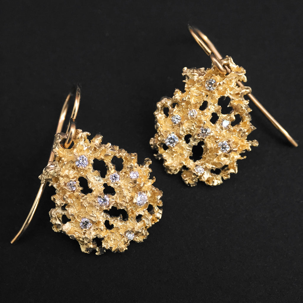 Lacy, textured, substantial pear-shaped earring with matte and polished portions and 8 white diamonds