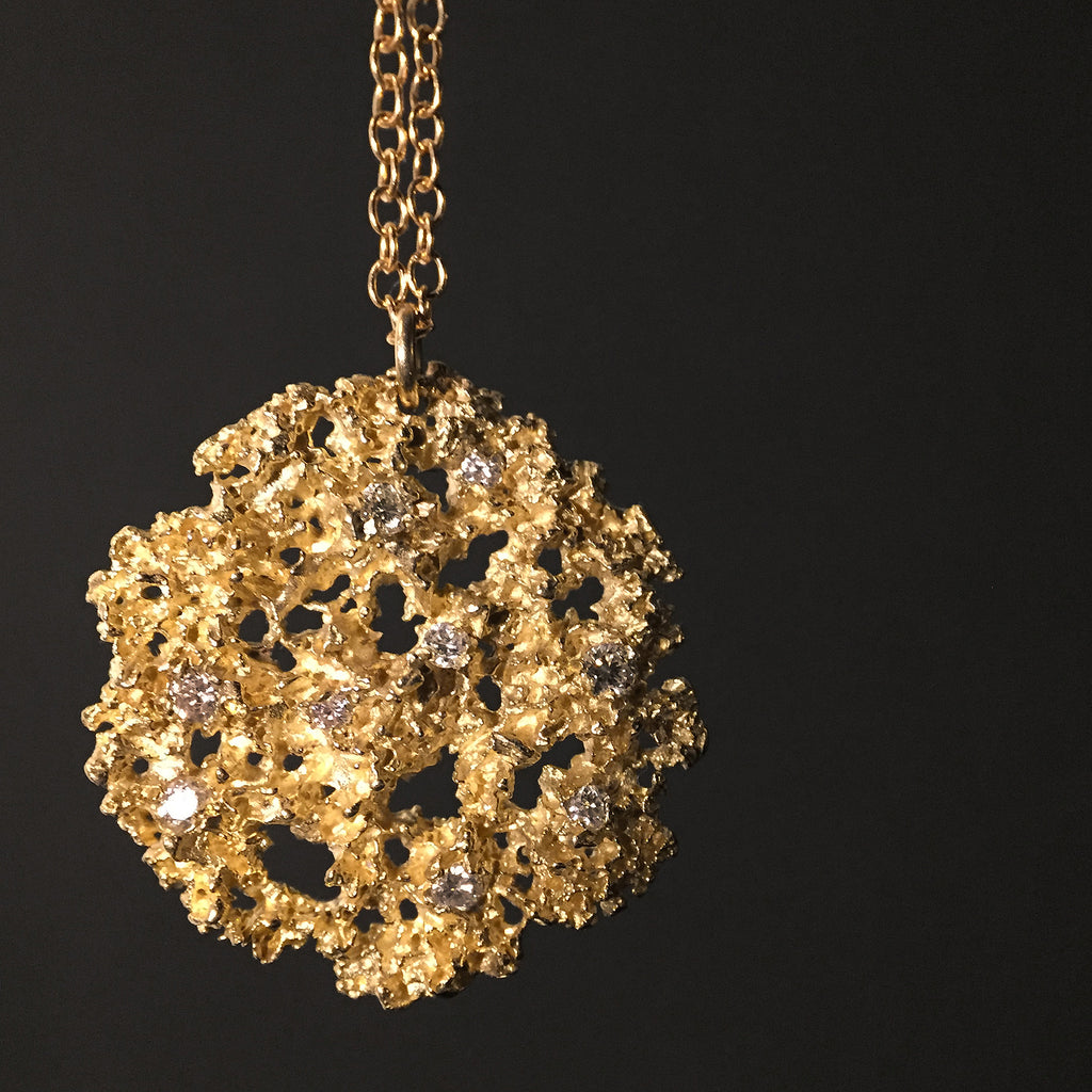 Substantial, heavily-textured, rounded pendant with lacy organic negative space; shown with scattered white diamonds in various sizes 