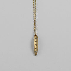 Very small, narrow leaf pendant; shape is slightly convex with vertical crease in center; shown in yellow gold; 5 diamonds in crease