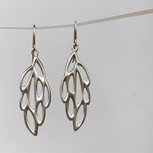 Wing-shaped earring on wire has cutouts resembling the pattern of a moth wing