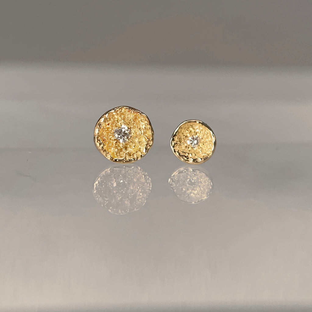 Taxtured, concave, round pod with diamond in center; shown in two sizes