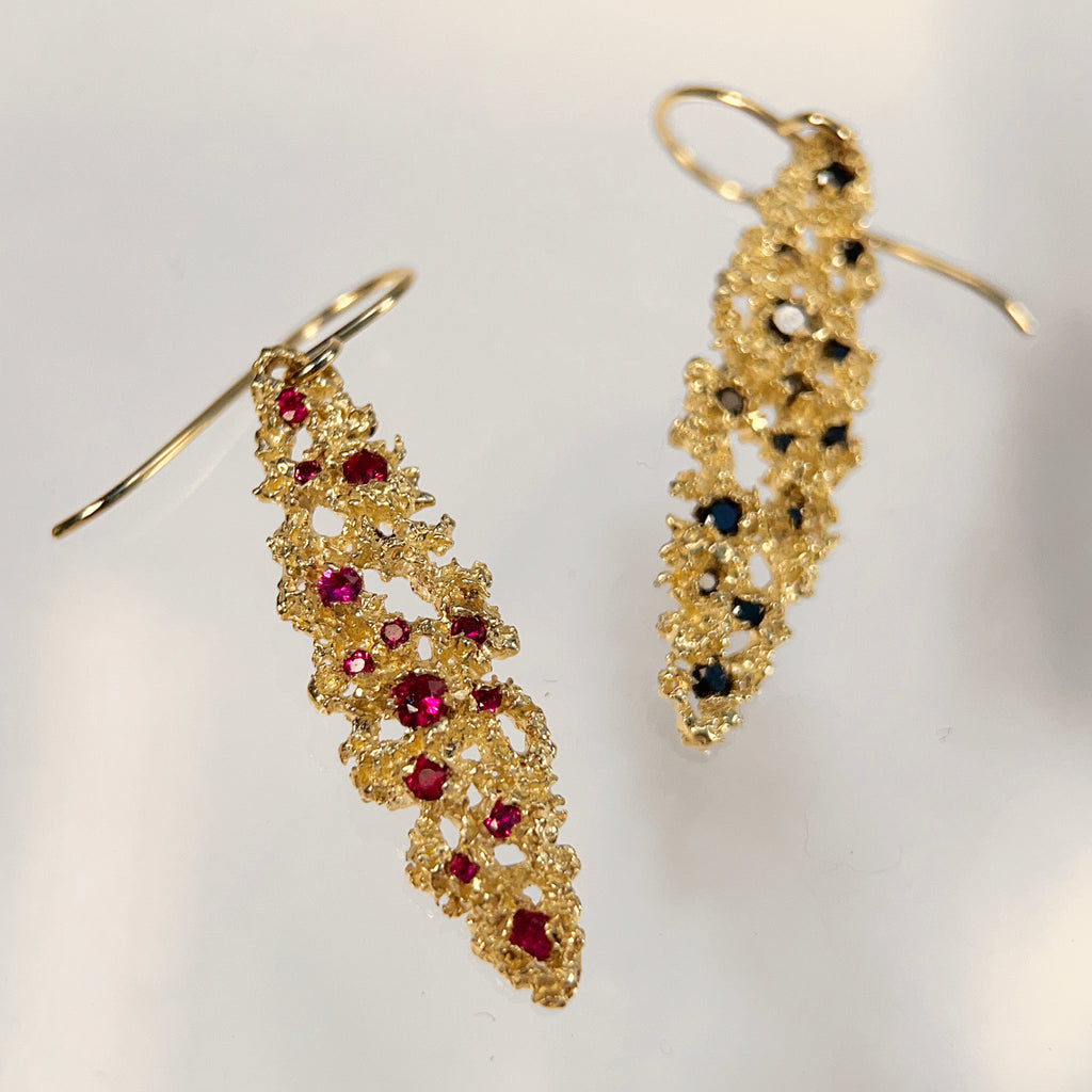 Textured ellipse-shaped earring on wire, shown with black diamond and ruby options