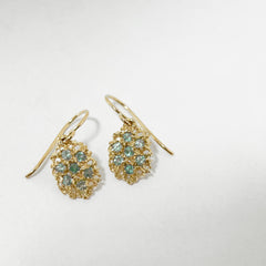 Textured, lacy, lemon-shaped earring, shown in yellow gold with a soft watery palette of alexandrite greens