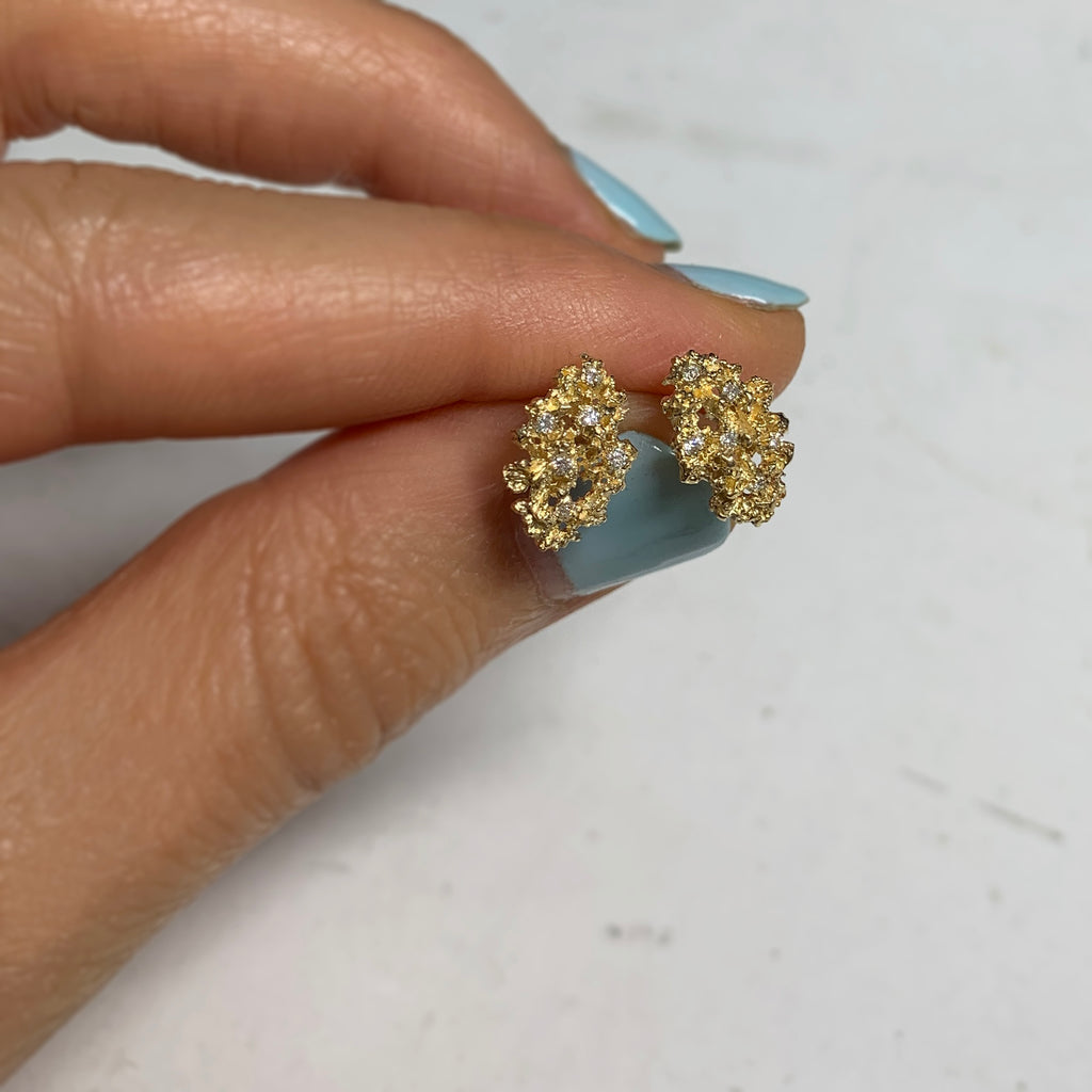 Small, lacy, textured, shiny, marquise-shaped post earrings that curve just slightly under ear lobe; each studded with 6 1/2 pt diamonds; shown in 14k yellow gold