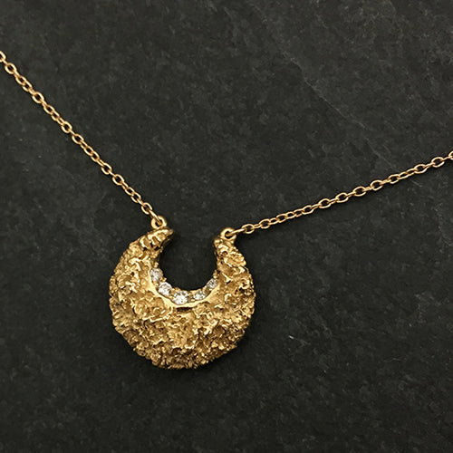 Textured and polished crescent moon pendant with diamonds in inner curve; shown in polished gold