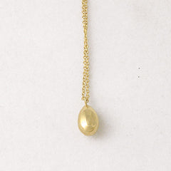 Shiny, solid egg necklace shown in yellow gold.