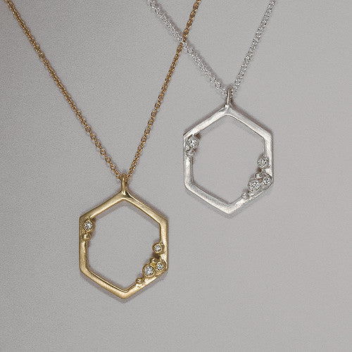Hollow, open hexagon pendant with 4 diamond "buds" placed asymmetrically; shown in yellow gold and silver
