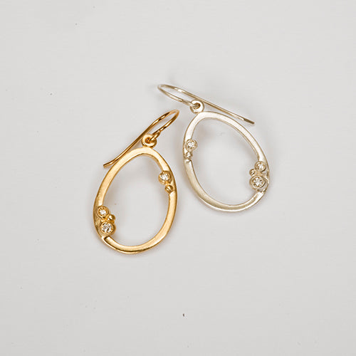 Hollow, open oval with 3 diamond "buds" placed asymmetrically; shown in yellow gold and silver; wire earring