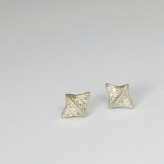 Diamond-shaped stud with raised center line; pavé diamonds on either side of center line; shown in silver