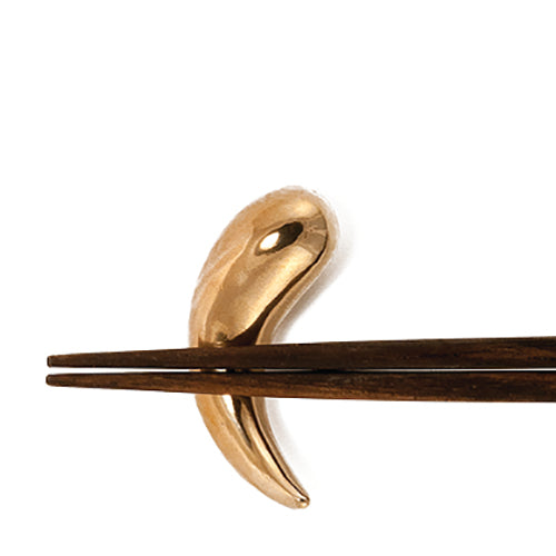 horn-shaped object that can be used as chopstick rest; solid, polished bronze
