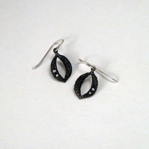 Small, textured, blackened, marquise shape with opening in middle; white diamonds in lower corner on one side of each earring