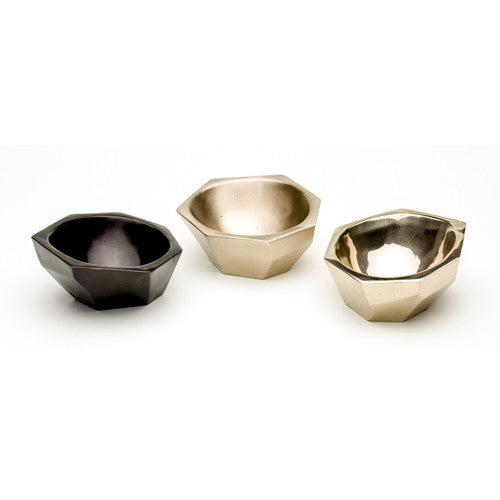 Shallow, asymmetrical bowl of heavy, cast bronze that is faceted on the outside and smooth on the inside