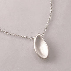 Paisley-shaped, substantial concave shell pendant; soft; hidden bail 