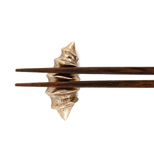 Ridged, croissant-shaped chopstick rest of solid cast bronze 
