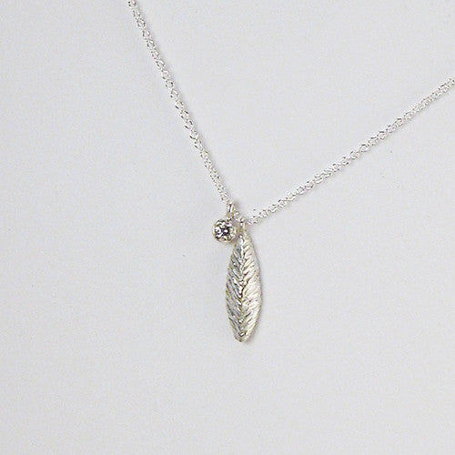 Small, textured, leaf-like pendant with separate 7 pt white diamond charm