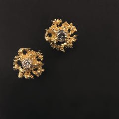 Lacy, textured, star-like stud earring has center stone; shown here with white and grey diamond options