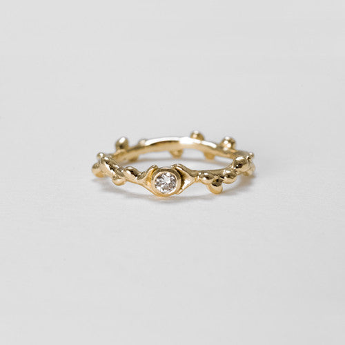 Branch-like ring with center stone an tiny wishbone detail on either side of bezel